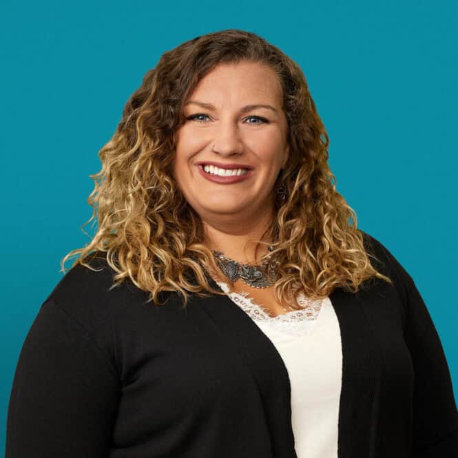 Professional headshot of Melissa Einink, APRN-CNP, smiling woman with curly blonde hair in black cardigan.