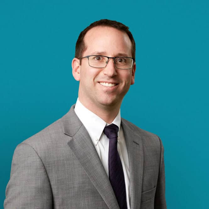 Professional headshot of Michael D. Johnson, MD in gray suit against teal background