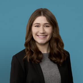 Professional headshot of Michaela Fritson, PA-C smiling in business attire against blue background