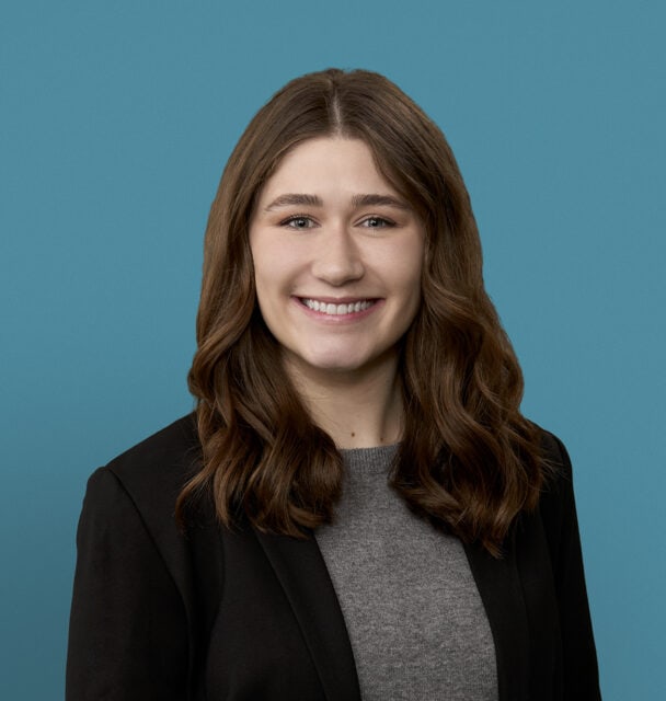 Professional headshot of Michaela Fritson, PA-C smiling in business attire against blue background