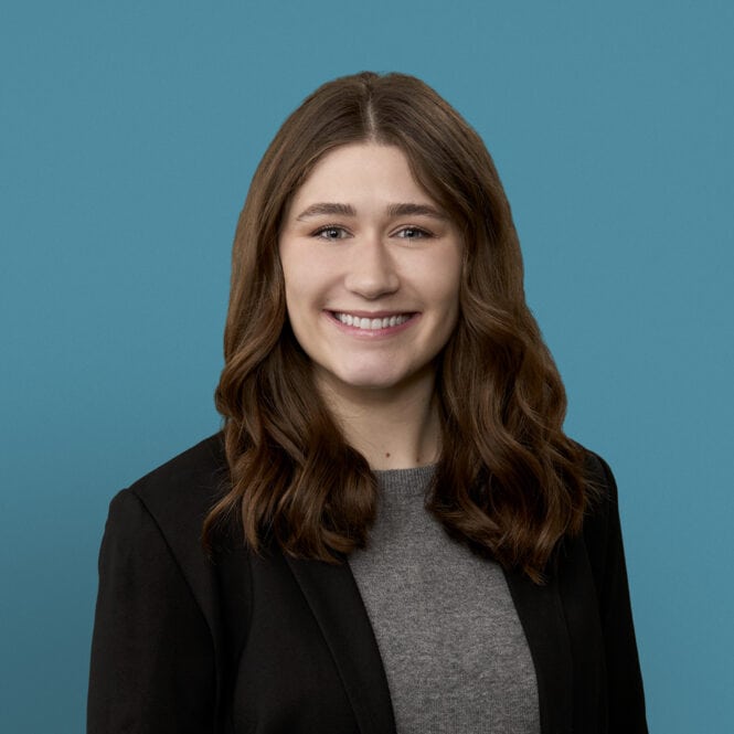 Professional headshot of Michaela Fritson, PA-C smiling in business attire against blue background