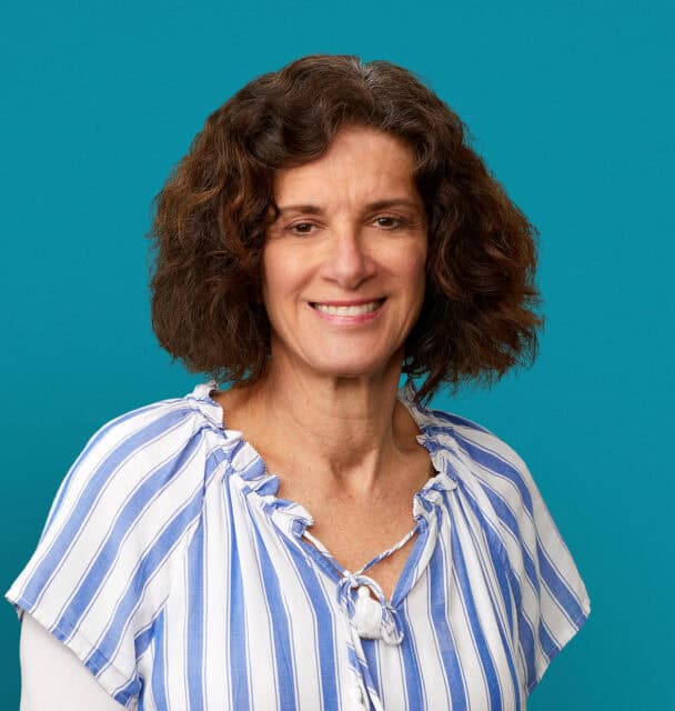 Professional headshot of Michele M. Geiger, RD in blue striped blouse against teal background