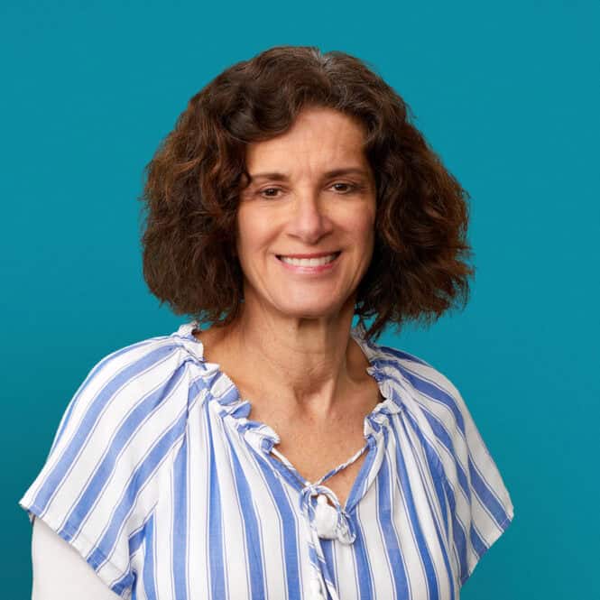 Professional headshot of Michele M. Geiger, RD in blue striped blouse against teal background