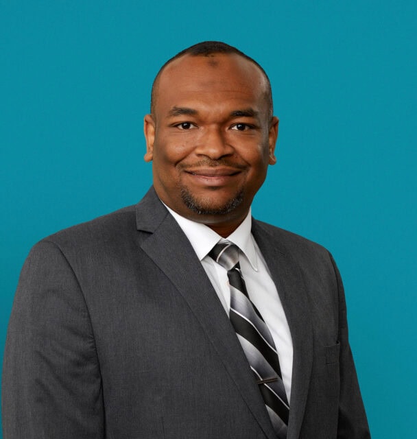 Professional headshot of Mohamed Abdelrahman, MD in gray suit with striped tie