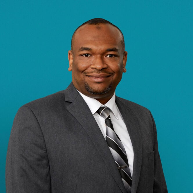 Professional headshot of Mohamed Abdelrahman, MD in gray suit with striped tie