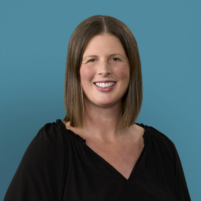 Professional headshot of Molly Bowman, RN, smiling in black top against blue background