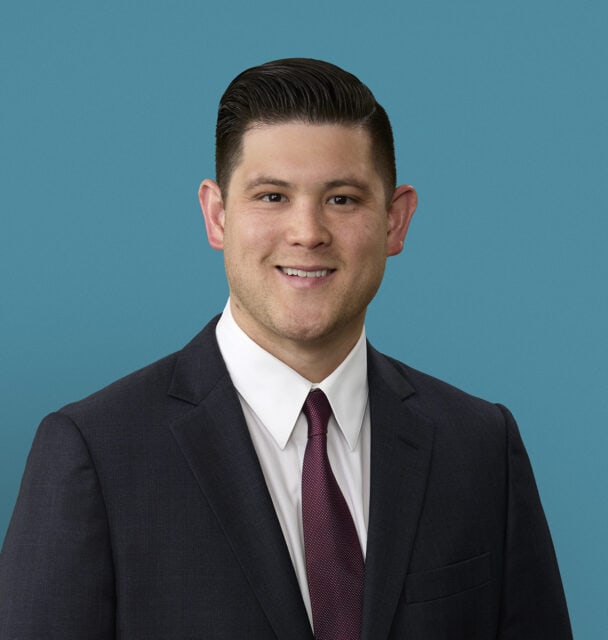 Professional headshot of Dr. Nate Han in dark suit and burgundy tie