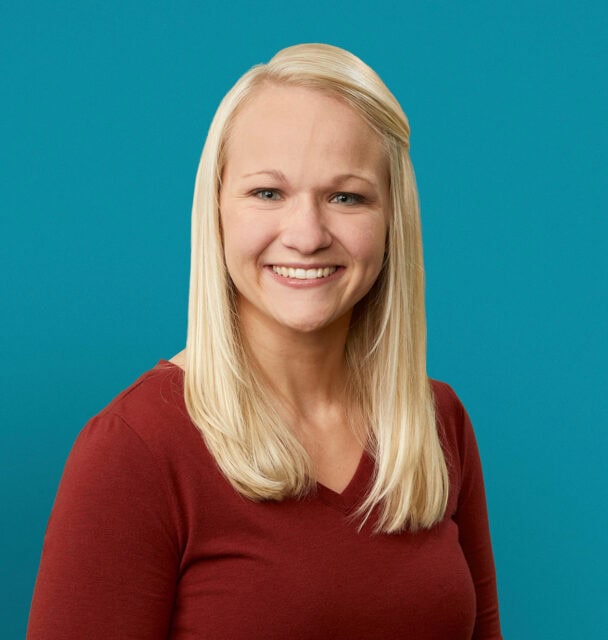 Professional headshot of Patricia Pienaar, PA-C, smiling in red top against teal background