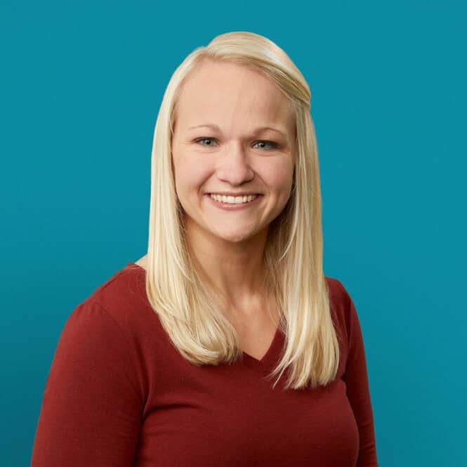 Professional headshot of Patricia Pienaar, PA-C, smiling in red top against teal background