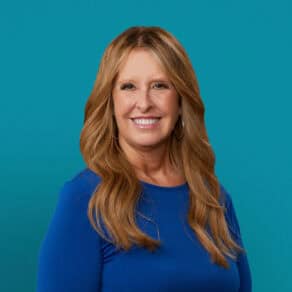 Professional headshot of Penny Drazer, APRN-CNP in blue top against teal background