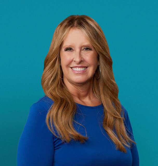 Professional headshot of Penny Drazer, APRN-CNP in blue top against teal background