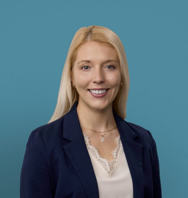 Professional headshot of Rachael Bauer, PA-C in navy blazer against teal background