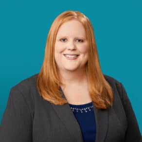 Professional headshot of Rachael Lamb, APRN-CNP, smiling in gray blazer and blue top