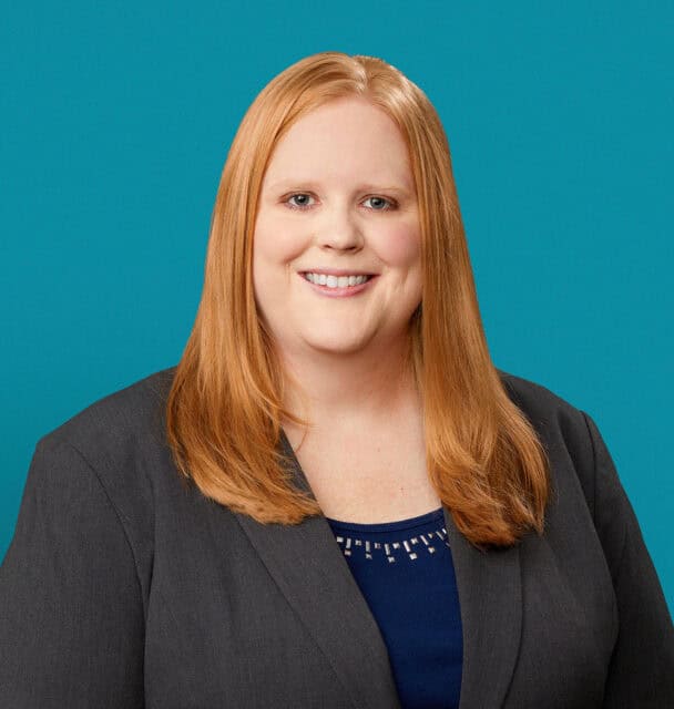 Professional headshot of Rachael Lamb, APRN-CNP, smiling in gray blazer and blue top