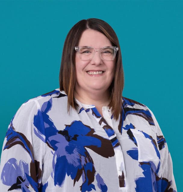 Professional headshot of Rachel Bird, APRN-CNP, smiling woman with glasses and floral blouse