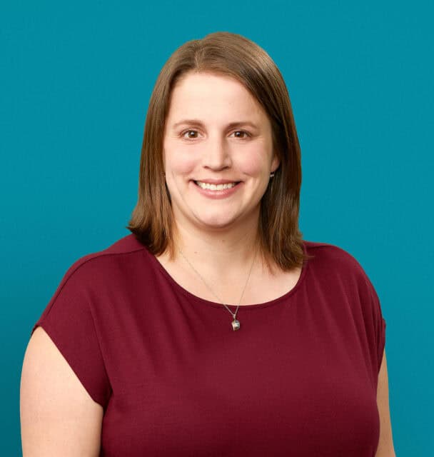 Professional headshot of Rachel S. June, MD smiling in burgundy top against teal background