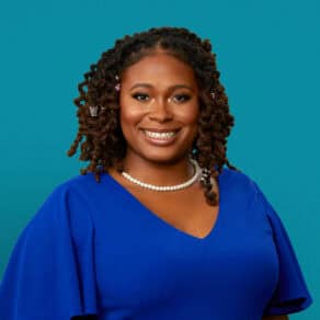 Professional headshot of Rachelle Dulan Hood, DO wearing blue top with pearl necklace