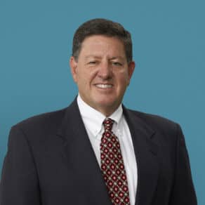 Professional headshot of Robert T. McClure, MD in dark suit with red patterned tie
