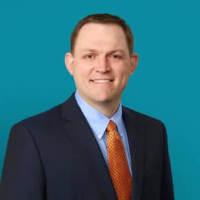 Professional headshot of Scott R. Day, PA-C in navy suit with orange patterned tie