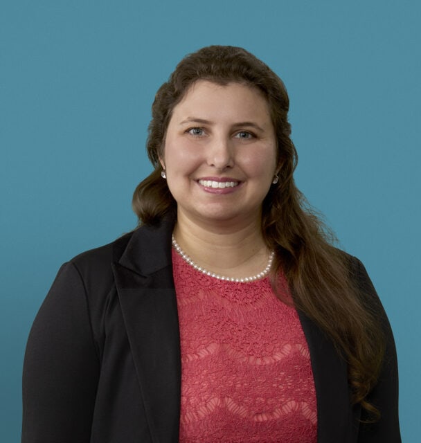 Professional headshot of Shaher-Baano Haider, MD in business attire against blue background