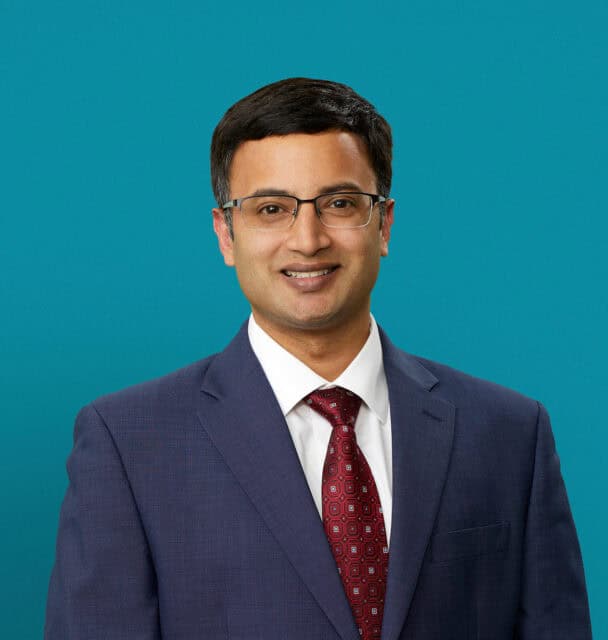 Professional headshot of Dr. Shashank Sarvepalli in navy suit with red patterned tie