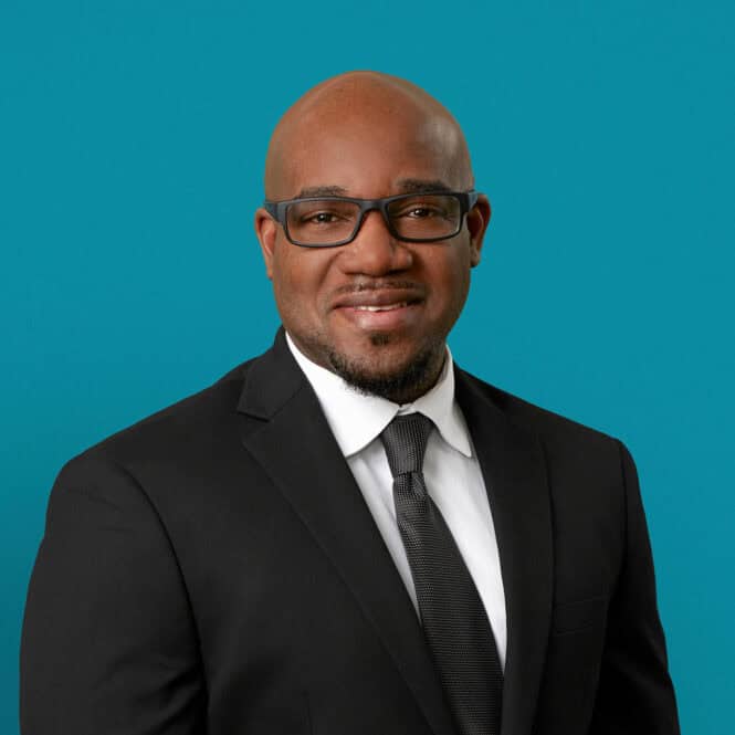 Professional headshot of Stedman E. Hughes, APRN-CNP in business attire against teal background