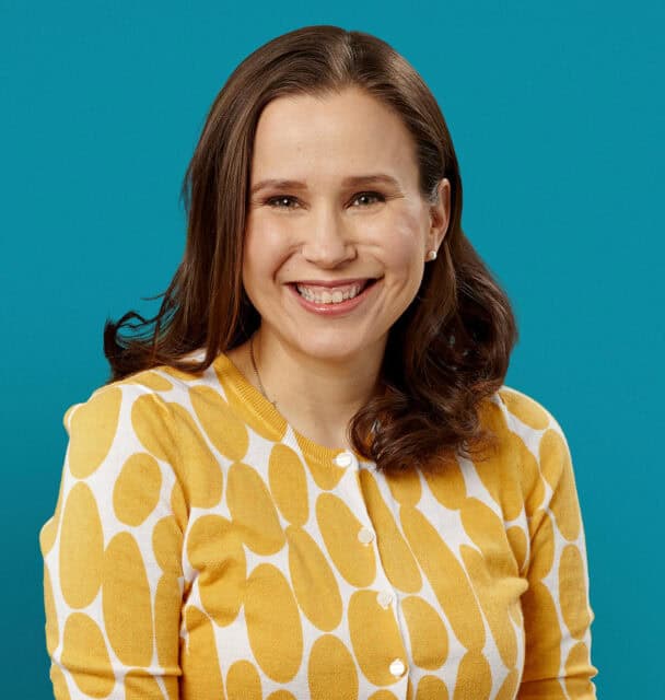Professional headshot of Dr. Suzanne L. Bell smiling in yellow patterned cardigan
