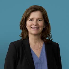 Professional headshot of Tiffany D. Williams, APRN-CNP, smiling in business attire against blue background.