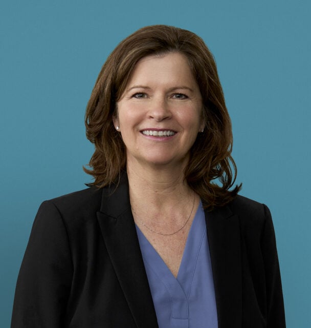 Professional headshot of Tiffany D. Williams, APRN-CNP, smiling in business attire against blue background.
