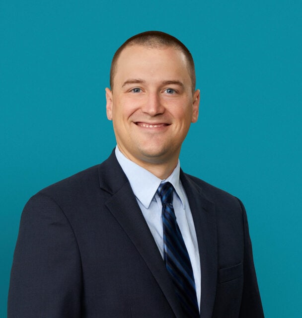 Professional headshot of Dr. Timothy Bennett in dark suit and blue tie