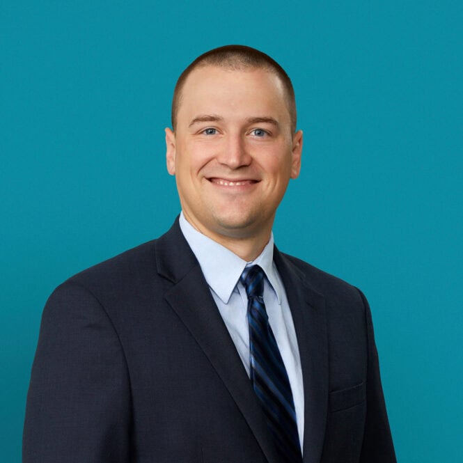Professional headshot of Dr. Timothy Bennett in dark suit and blue tie