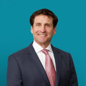 Professional headshot of Dr. Timothy F. Peters in navy suit with red tie