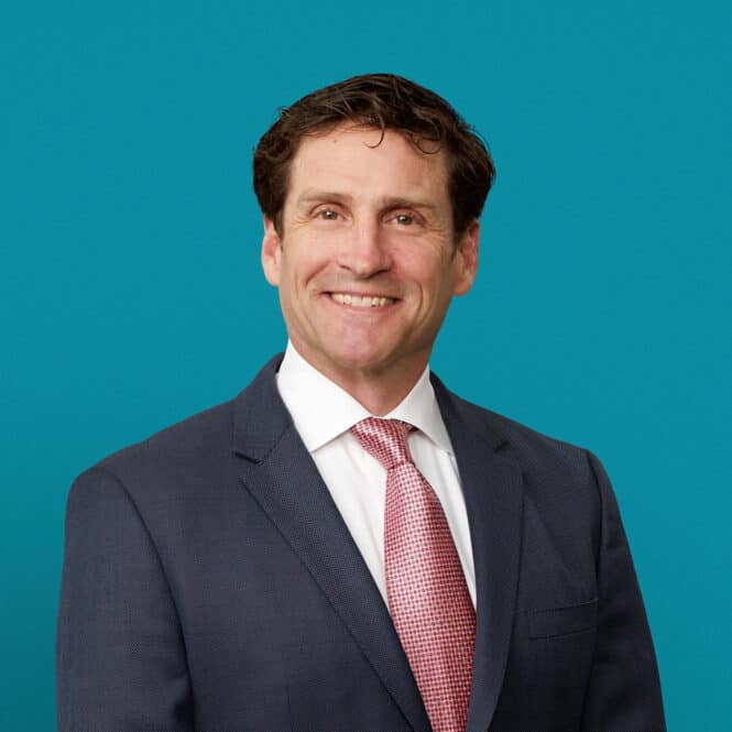 Professional headshot of Dr. Timothy F. Peters in navy suit with red tie