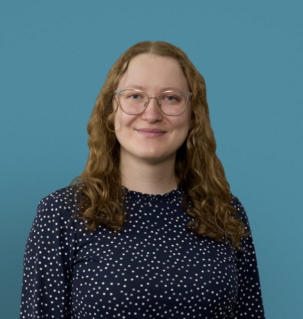 Professional headshot of Dr. Tori Severs wearing glasses and polka dot top against blue background