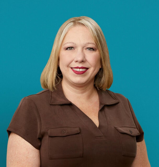 Professional headshot of Wendy Fields, APRN-CNP, smiling in brown shirt against teal background.