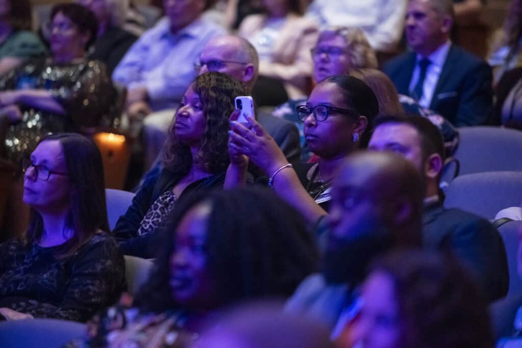 Audience members watching the presentation