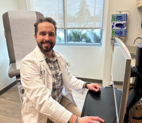 Dr. de la Pena at a computer in an exam room.