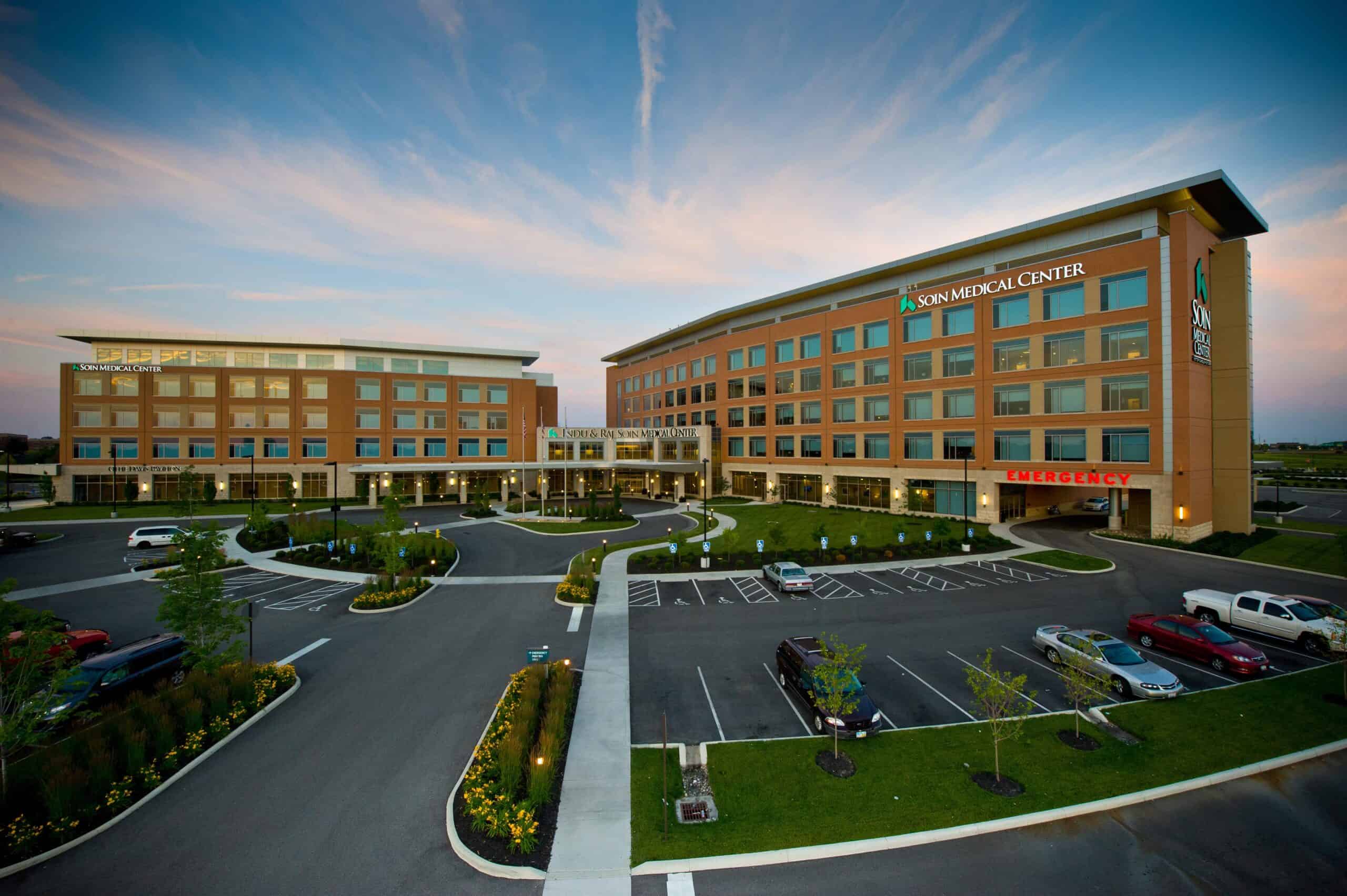 Soin Medical Center exterior view showing modern healthcare facility buildings with parking area at dusk