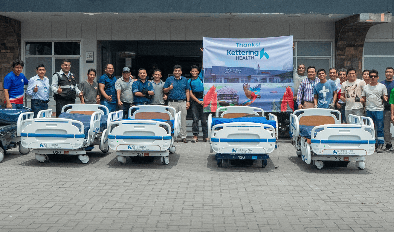 Group of healthcare workers posing with donated hospital beds from Kettering Health