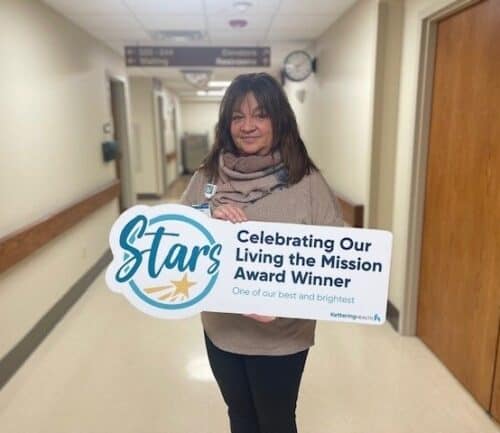 Andrea McKenna posing for picture with Living the Mission Award sign