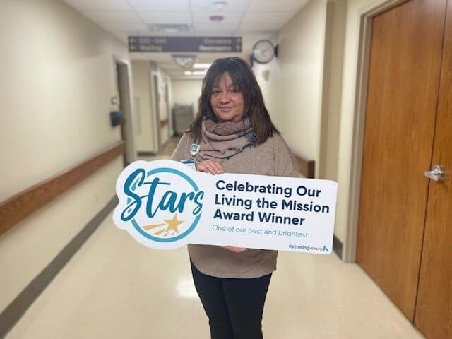 Andrea McKenna posing for picture with Living the Mission Award sign