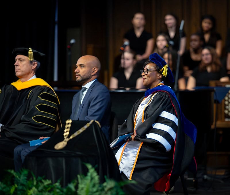Dr. Mitchell sitting and smiling during the ceremony